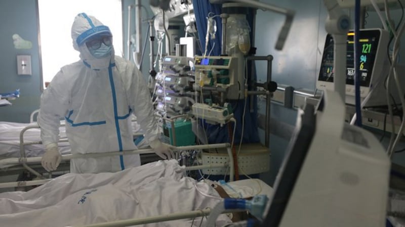 2020年2月13日,医务人员在武汉金银潭医院重症监护病房(ICU)内检查重症肺炎患者。(路透社)